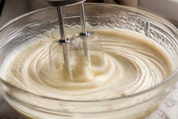 مخلوط کردن تخم‌مرغ و شکر در تهیه کیک صبحانه