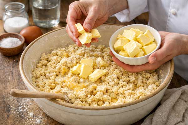 مخلوط کردن مواد با مارگارین در تهیه نان شیرمال با کره مارگارین