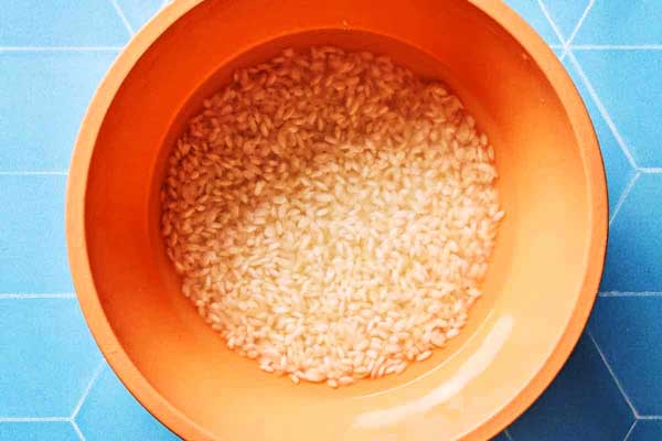خیساندن برنج برای تهیه اسفناج پلو 