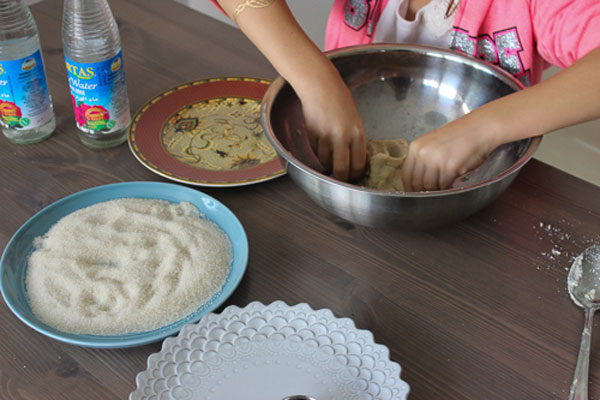 ورز دادن خمیر شیرینی توت بادامی با دست 
