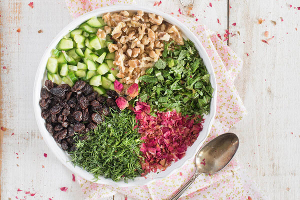 خیار، گردو، کشمش و سبزی تازه خرد شده برای تهیه آب دوغ خیار ساده