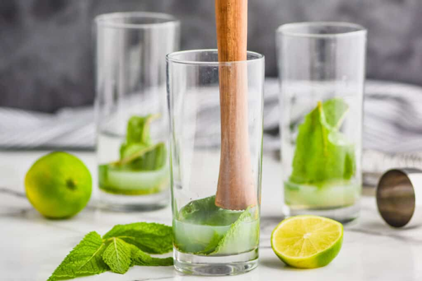 فشردن نعناع و آبلیمو برای تهیه موهیتو خانگی 
