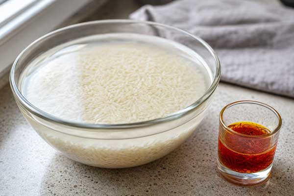 خیساندن برنج و دم کردن زعفران برای تهیه گیپای کرمان