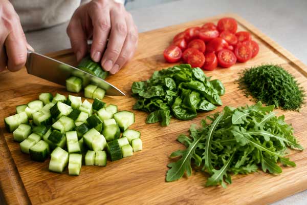 خرد کردن خیار، گوجه، شوید و ریحان برای تهیه سالاد سبزیجات با پنیر بوراتا