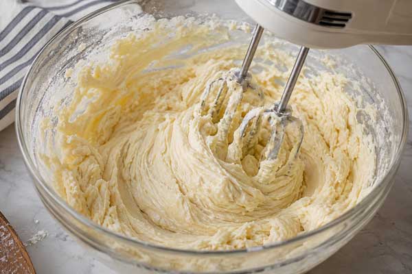 افزودن کره و نیمی از مخلوط تخم مرغ در تهیه پوند کیک