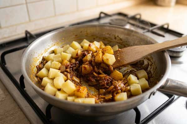 افزودن سیب زمینی پخته به پیاز داغ و پخت دو پیازه با آلو