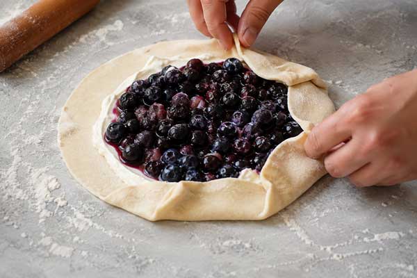 چیدن مواد گلت تابستانی روی خمیر هزارلا و تا زدن اطراف خمیر