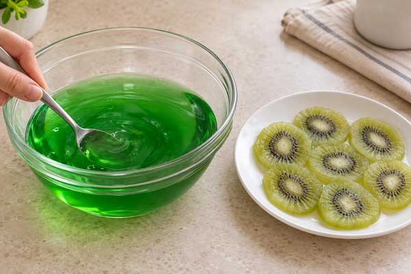 آماده کردن ژله سبز و کیوی برای روی کیک پودینگ