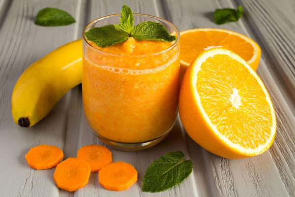 اسموتی پرتقال هویج و موز تزیین شده با نعناع 