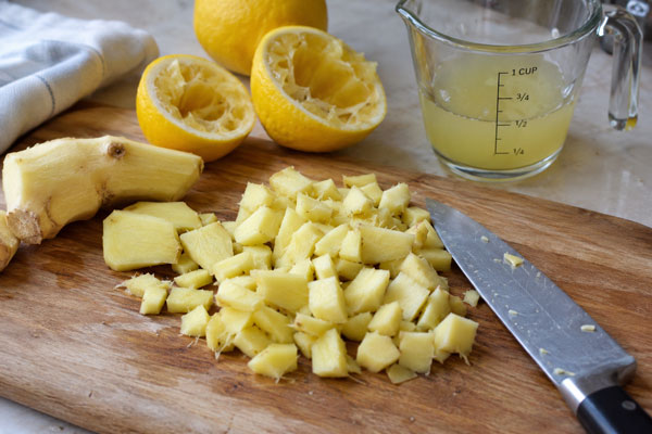 آب گرفتن لیموترش و خرد کرن زنجبیل برای تهیه نوشیدنی زنجبیل و لیمو